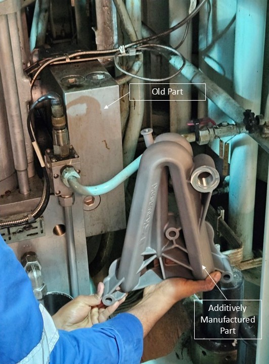 The original installed standpipe and its additively manufactured replacement, held side by side in the engine space